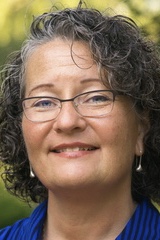 Close-up portrait of person smiling with glasses.